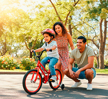 Foto-de-niño-en-un-parque-andando-en-bicicleta-con-sus-padres