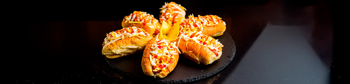 Foto de un plato con 6 hot dogs o perros calientes estilo venezolano.