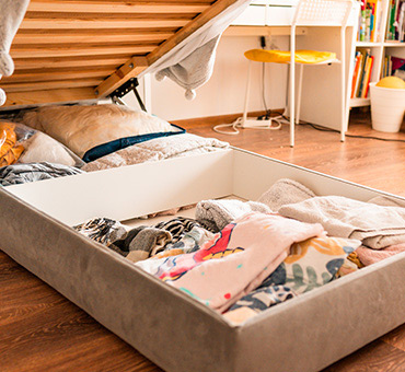 Foto de una cama que se abre y tiene espacio para almacenar sábanas y almohadas en la parte inferior.