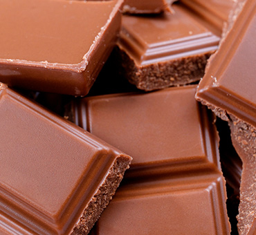 Foto en plano detalle de una barra de chocolate troceada.