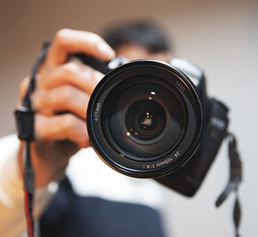 Foto de un fotógrafo apuntando la cámara directamente hacia nosotros, a punto de tomar una foto